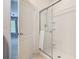 Updated shower with white subway tile and glass door, showing adjacent bedroom at 422 Armoyan Way, New Smyrna Beach, FL 32168
