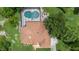 Aerial view of a private pool and well maintained roof, surrounded by a lush green lawn and mature trees at 43350 Natchez St, Deland, FL 32720