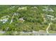 An aerial view shows the home surrounded by green trees, highlighting the peaceful location and seclusion at 43350 Natchez St, Deland, FL 32720