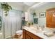 Well-lit bathroom featuring a toilet, vanity, mirror, and hanging plants, creating a refreshing space at 43350 Natchez St, Deland, FL 32720