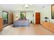 Bright bedroom features a large bed, neutral decor, and a dresser, creating a serene and inviting atmosphere at 43350 Natchez St, Deland, FL 32720