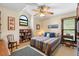 Cozy bedroom includes a window, shelving unit with books, striped comforter, and ceiling fan at 43350 Natchez St, Deland, FL 32720