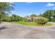 Wide driveway leads to a brick home with lush green lawn, mature trees, and well manicured landscaping at 43350 Natchez St, Deland, FL 32720