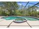 The screened-in pool features a unique shape and attached spa with plenty of room for entertaining at 43350 Natchez St, Deland, FL 32720