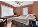 Inviting bedroom with hardwood floors, two large windows, and a comfortable bed at 441 N Julia Ave, Deland, FL 32720