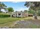 Charming stucco home featuring unique architectural details, a well-maintained lawn and a carport at 441 N Julia Ave, Deland, FL 32720