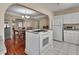 Open-concept kitchen featuring white cabinets, stainless steel appliances, and dining area with natural light at 441 N Julia Ave, Deland, FL 32720