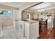 Bright and airy kitchen with white cabinets, tile flooring, and an adjacent dining area with hardwood floors at 441 N Julia Ave, Deland, FL 32720