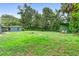 Spacious backyard featuring lush greenery, storage sheds, and a fire pit perfect for outdoor gatherings at 507 Sand Ave, Apopka, FL 32703