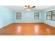 Bright bedroom with wood laminate floors, three windows, and ceiling fan at 507 Sand Ave, Apopka, FL 32703