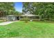 Well-manicured lawn and landscaping enhance this home's exterior, featuring a screened porch and carport at 507 Sand Ave, Apopka, FL 32703
