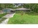 This charming home features a screened-in porch, covered parking, and a beautifully maintained front yard at 507 Sand Ave, Apopka, FL 32703