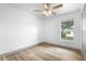 Well-lit bedroom featuring a ceiling fan, wood-look flooring, and a view of the front yard at 510 Apollo Ave, Deltona, FL 32725