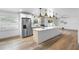 This bright, open kitchen features stainless steel appliances, quartz countertops, a large island, and stylish pendant lighting at 510 Apollo Ave, Deltona, FL 32725