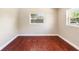This bedroom features hardwood floors and has natural light from two windows at 5204 Van Aken Dr, Orlando, FL 32808