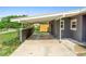 Exterior shot of a carport and house with gray paint and manicured lawn at 5204 Van Aken Dr, Orlando, FL 32808