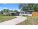 Inviting single-story home with a long driveway, white trim, gray brick, and a freshly landscaped front yard at 5204 Van Aken Dr, Orlando, FL 32808