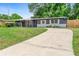 Inviting single-story home with a long driveway, white trim, gray brick, and a freshly landscaped front yard at 5204 Van Aken Dr, Orlando, FL 32808