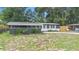 Charming single-story home featuring gray brick, white trim, and a well-manicured lawn with lots of trees at 5204 Van Aken Dr, Orlando, FL 32808