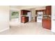 Bright kitchen with dark cabinets, white appliances, and tiled floor open to adjoining rooms and backyard views at 5204 Van Aken Dr, Orlando, FL 32808