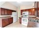 Functional kitchen with wood cabinets, white appliances, and plenty of counter space at 5204 Van Aken Dr, Orlando, FL 32808