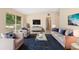 Inviting living room with stylish furniture, a blue rug, and a serene view through large windows at 5204 Van Aken Dr, Orlando, FL 32808