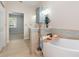 Bathroom featuring a soaking tub, dual sink vanity and tile floors at 5445 Turton Ln, Port Orange, FL 32127