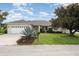 Charming single-story home boasts a two-car garage and well-manicured lawn with mature landscaping at 5445 Turton Ln, Port Orange, FL 32127