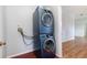 A stacked washer and dryer set in a laundry area with wood-look floors at 5445 Turton Ln, Port Orange, FL 32127