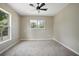 Neutral bedroom features neutral walls and carpet and a ceiling fan and lots of natural light at 570 Cypress Ave, Orange City, FL 32763