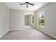 Bedroom features neutral walls and carpet, closet with mirrored doors, a ceiling fan, and lots of natural light at 570 Cypress Ave, Orange City, FL 32763