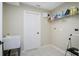 Functional laundry room featuring utility sink, storage shelf, and tile flooring at 570 Cypress Ave, Orange City, FL 32763