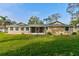 Expansive backyard view shows a well-maintained lawn and neutral home exterior at 65 Sycamore Cir, Ormond Beach, FL 32174