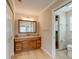 This bathroom features tile floors, wood cabinets, a large mirror, and a walk-in shower at 65 Sycamore Cir, Ormond Beach, FL 32174