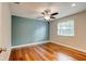 This bedroom features hardwood floors, a ceiling fan, and natural light at 65 Sycamore Cir, Ormond Beach, FL 32174