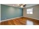 A bright bedroom with beautiful hardwood floors, a ceiling fan, and lots of natural light at 65 Sycamore Cir, Ormond Beach, FL 32174