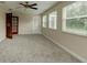 Bright bedroom with new carpet, ceiling fan, three windows, and access to a separate exterior at 65 Sycamore Cir, Ormond Beach, FL 32174