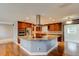 Open kitchen with granite island, stainless appliances, custom cabinets, and eat-in area with wood floors at 65 Sycamore Cir, Ormond Beach, FL 32174