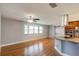 Open living area with hardwood floors, ceiling fan, and view of kitchen with stainless steel appliances at 65 Sycamore Cir, Ormond Beach, FL 32174