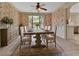 Floral wallpaper accentuates a dining room with a natural wood dining table set for six and a view of the exterior at 658 Westchester Dr, Deland, FL 32724