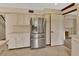 Spacious kitchen boasts modern stainless-steel refrigerator and ample counter space with white cabinets and tile flooring at 658 Westchester Dr, Deland, FL 32724