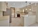 Well-lit kitchen with tile flooring, light-colored cabinets, stainless steel appliances, and a view of the dining room at 658 Westchester Dr, Deland, FL 32724