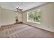 Open living room with large window and access to the stairway at 658 Westchester Dr, Deland, FL 32724