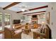 Cozy living room features a brick fireplace, wood beams, built-in shelving, and comfortable seating at 658 Westchester Dr, Deland, FL 32724