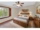 Cozy main bedroom featuring a wood frame bed, ceiling fan and ample natural light at 658 Westchester Dr, Deland, FL 32724