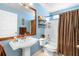 Charming bathroom featuring a pedestal sink and shower-tub combination with a brown shower curtain at 824 Casterton Cir, Davenport, FL 33897