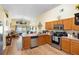 Open kitchen area with wooden cabinets, stainless steel appliances, and hardwood flooring at 824 Casterton Cir, Davenport, FL 33897