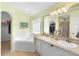 Bright main bathroom with double sinks, a walk-in closet, and a separate tub and shower at 824 Casterton Cir, Davenport, FL 33897