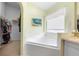 Bright main bathroom featuring garden tub, window, and walk-in closet at 824 Casterton Cir, Davenport, FL 33897