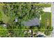 Aerial view of a home with a spacious yard, mature trees, and a paver driveway at 832 Donnelly Pl, Daytona Beach, FL 32114